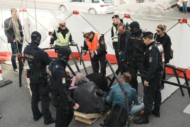 Polizisten stehen um eine Gruppe Aktivisten