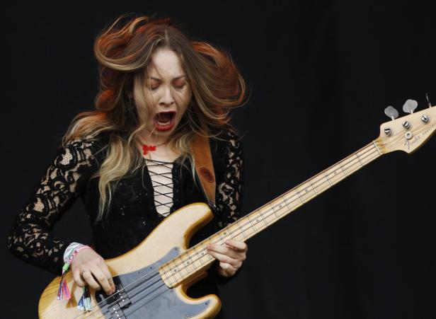 Eine Frau mit offenem Mund spielt auf einem Fender-Bass.