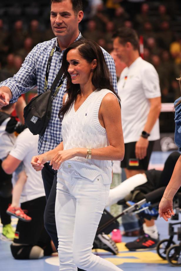 Meghan Markle im weißen Pollunder mit weißer Hose dazu.