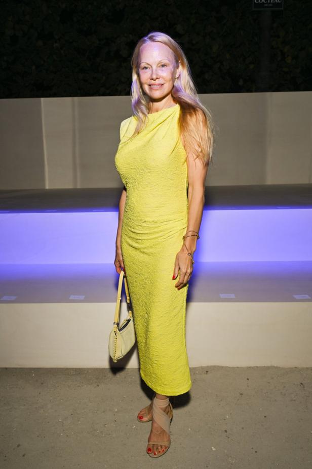 Pamela Anderson in einem gelben Kleid bei einer Veranstaltung.