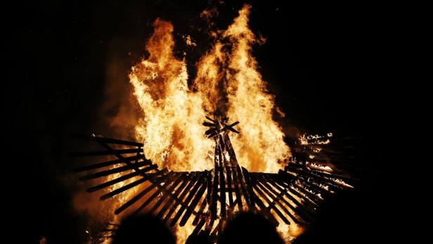 Ein großes Holzfeuer brennt in der Dunkelheit.