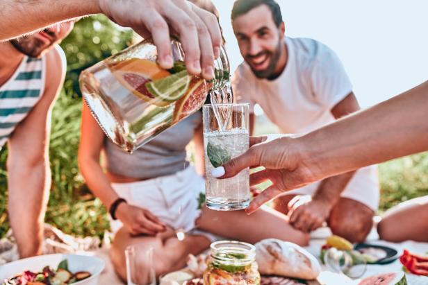 Gruppe Menschen mit Infused Water auf einer Decke.