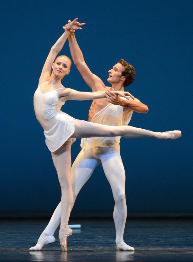 Ein Ballettpaar tanzt vor einem blauen Hintergrund.
