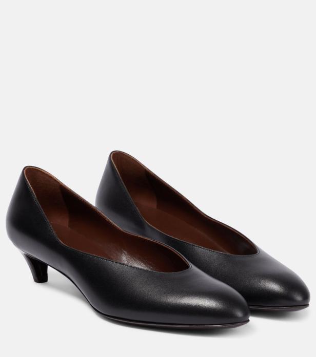 Ein Paar schwarze Lederpumps mit kleinem Absatz stehen auf einem weißen Hintergrund.
