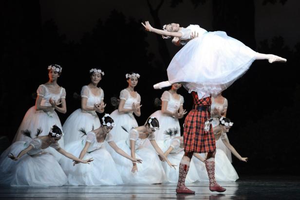 Eine Ballettaufführung mit einer Tänzerin, die von einem Mann in einem Schottenrock hochgehoben wird.