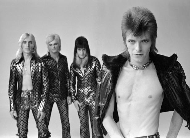 David Bowie und seine Band in glitzernden Outfits während seiner Ziggy Stardust-Ära.