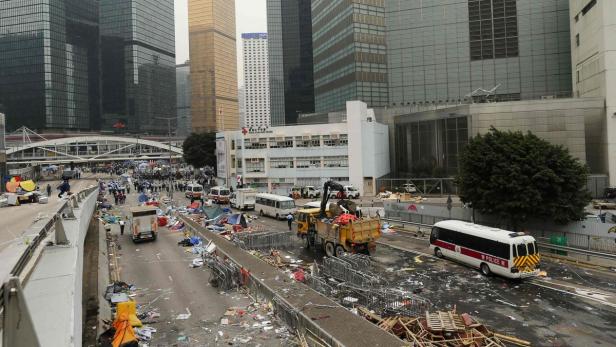 Nach einer Demonstration in Hongkong räumen Arbeiter die Straße auf.