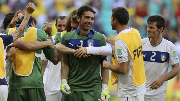 Gianluigi Buffon wird von seinen italienischen Teamkollegen umarmt.