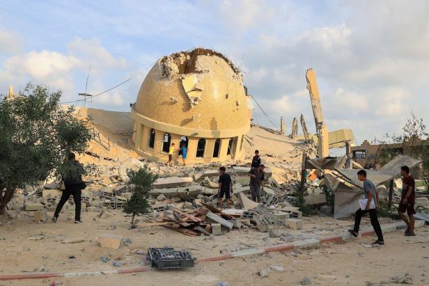 Menschen gehen am Sonntag an einer zerstörten Moschee in Khan Yunis im südlichen Gazastreifen vorbei.