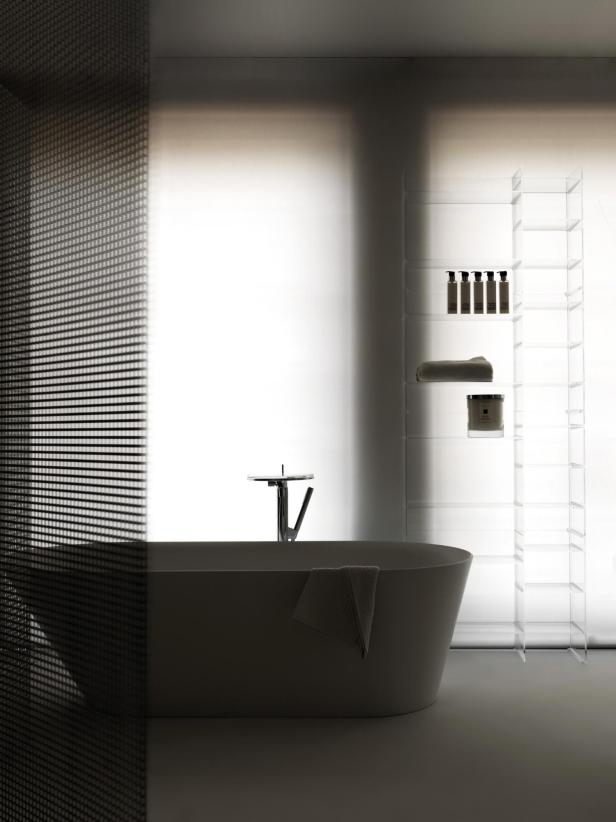 Ein Badezimmer mit einer freistehenden Badewanne und einem transparenten Regal.
