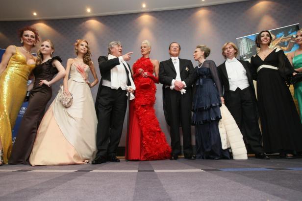 Eine Gruppe elegant gekleideter Menschen posiert für ein Foto.