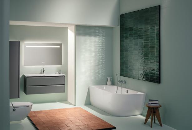 Ein modernes Badezimmer mit Badewanne, Waschtisch und grünen Akzenten.