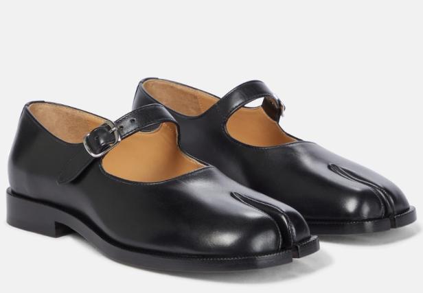 Zwei schwarze Mary-Jane-Schuhe mit Tabi-Zehen-Design stehen nebeneinander.