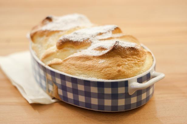 Ein Soufflé mit Puderzucker in einer blau-weiß karierten Form.