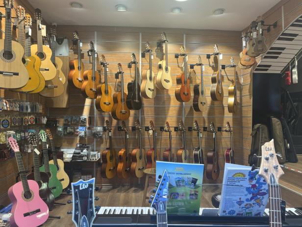 In einem Musikgeschäft hängen viele Gitarren an der Wand.