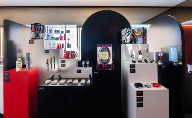 Ein Ausstellungsraum mit Campari-Flaschen, Gläsern und Werbeartikeln auf schwarzen und weißen Podesten.