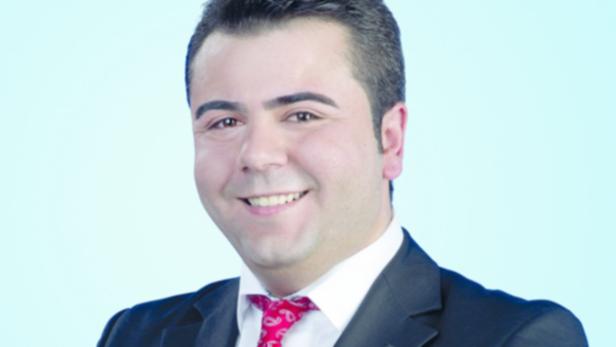 Osman Günes, SPÖ-Kandidat Salzburg Stadt, Vorwurf … Ein lächelnder Mann im Anzug mit roter Krawatte vor hellblauem Hintergrund.