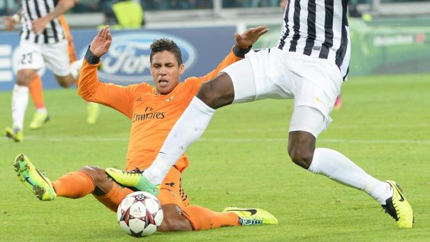 Ein Fußballspieler in Orange wird von einem anderen Spieler gefoult.