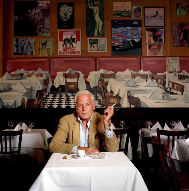 Ein Mann sitzt in einem Restaurant und raucht eine Zigarette.
