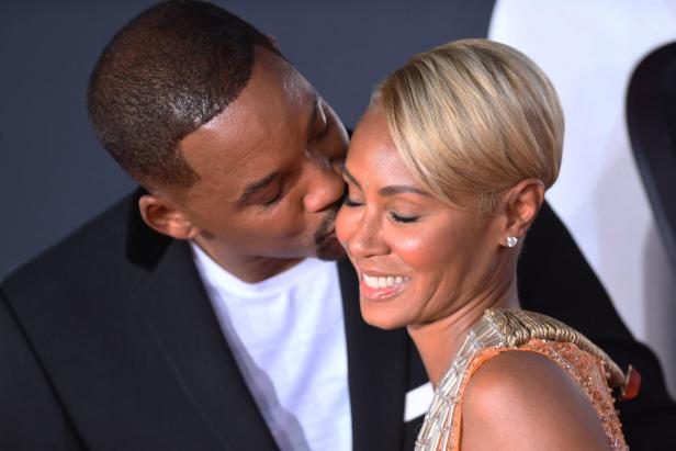 Will Smith küsst Jada Pinkett Smith auf die Wange.