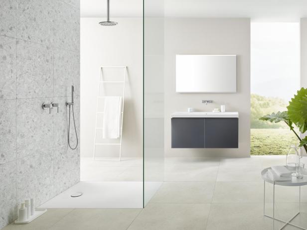 Ein modernes Badezimmer mit Dusche, Waschbecken und Blick ins Grüne.