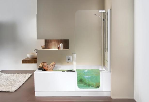 Eine Frau entspannt in einer Badewanne mit transparentem Seitenteil.