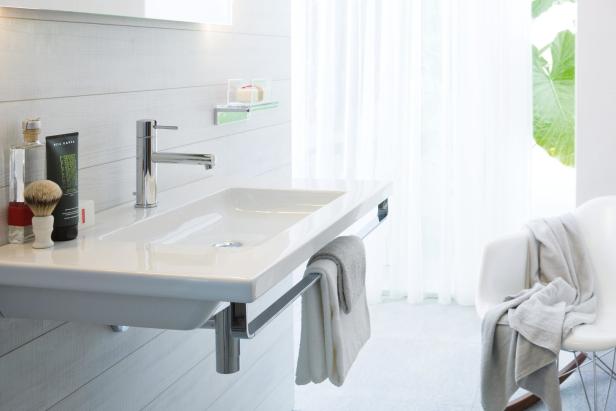 Ein modernes Badezimmer mit einem weißen Waschbecken und Handtüchern.