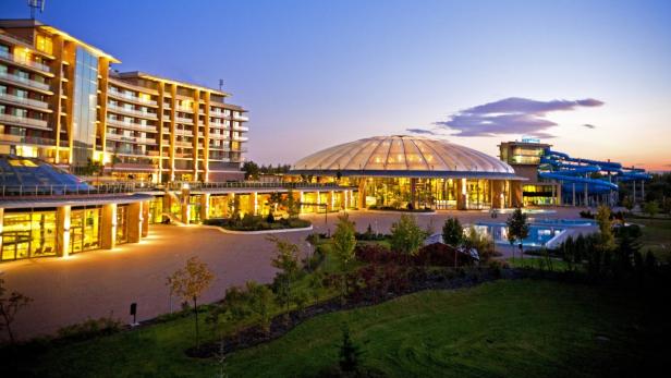 Ein großes Hotel mit einem Wasserpark bei Dämmerung.