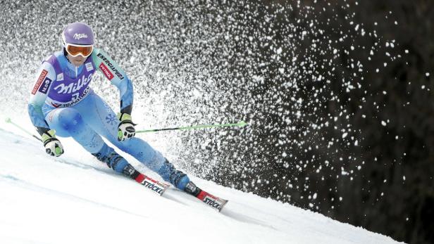 Eine Skirennläuferin fährt mit hoher Geschwindigkeit einen Hang hinunter.