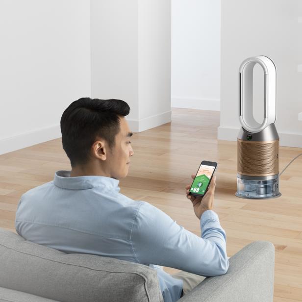 Ein Mann steuert einen Dyson Luftbefeuchter mit seinem Smartphone.