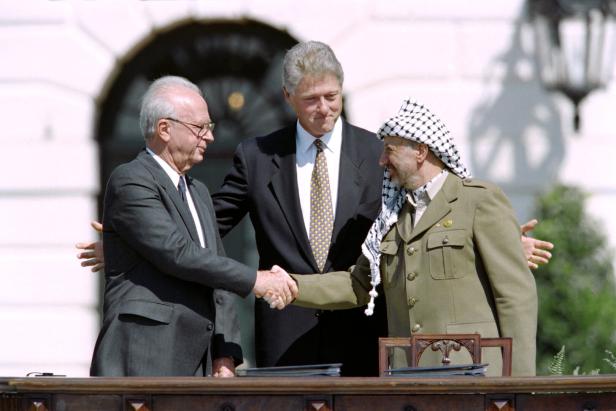 US-Präsident Bill Clinton zwischen PLO-Führer Yasser Arafat (r.) und dem israelischen Premierminister Yitzahk Rabin (l.) am 13. September 1993 im Weißen Haus in Washington, nachdem sie das historische Osloer Abkommen über palästinensische Autonomie in den besetzten Gebieten unterzeichnet haben.