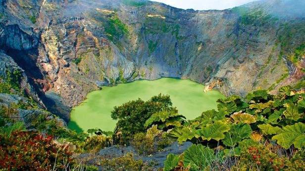 Der grüne Kratersee des Vulkans Irazú in Costa Rica, umgeben von steilen Felswänden und üppiger Vegetation.