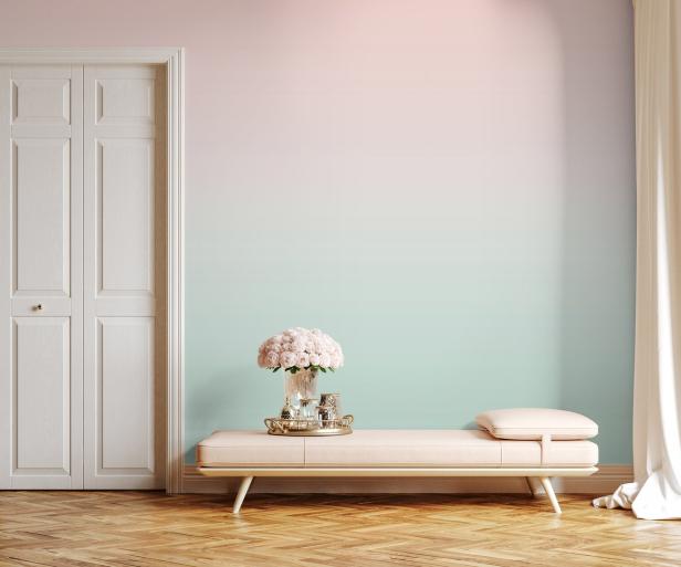 Einrichtung mit einer Bank, einem Blumenstrauß und einer Tür vor einer Wand mit Farbverlauf.