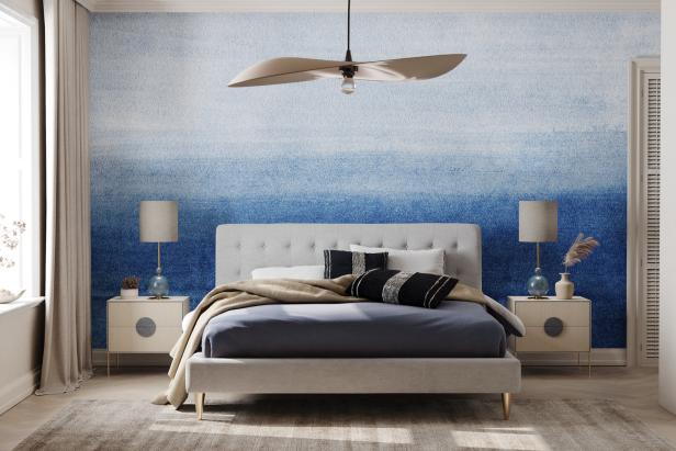 Ein Schlafzimmer mit einem Bett vor einer blau-weiß gestreiften Wand.