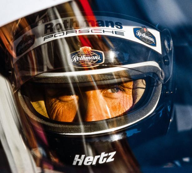 Nahaufnahme eines Rennfahrers mit „Rothmans Porsche“-Helm.