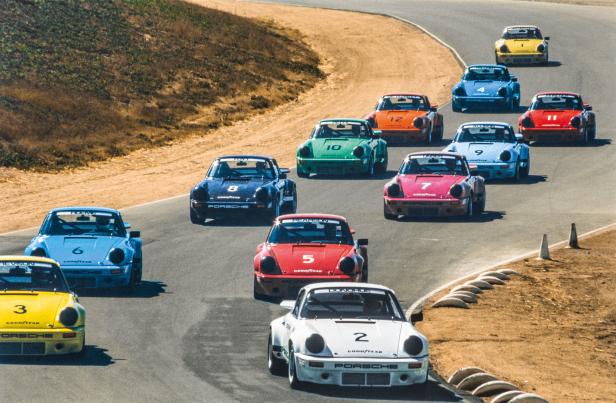 Eine Gruppe von Porsche-Rennwagen fährt auf einer kurvenreichen Strecke.