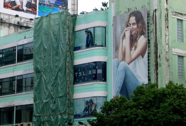 Ein Gebäude mit einem großen Werbeplakat einer Frau in Jeans.