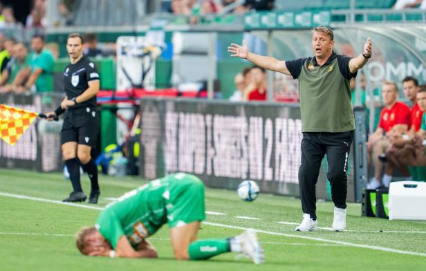 FUSSBALL - CONFERENCE LEAGUE - PLAY-OFF: SK RAPID WIEN - AC FIORENTINA Ein Fußballspieler liegt am Boden, während der Trainer gestikuliert und der Schiedsrichter die Fahne hält.