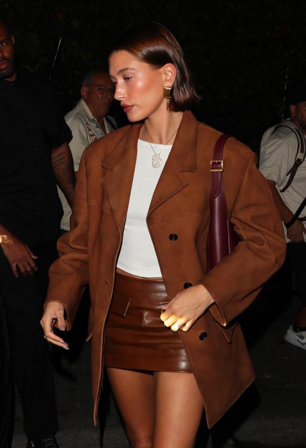 Hailey Bieber trägt einen braunen Blazer und einen Minirock.