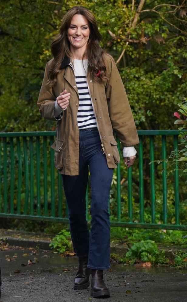 Prinzessin Kate trägt Jeans, ein gestreiftes Oberteil und eine braune Jacke.