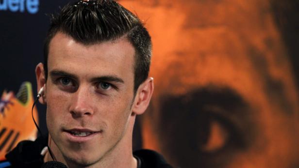 Nahaufnahme von Gareth Bale mit Kopfhörern vor einem orangefarbenen Hintergrund.