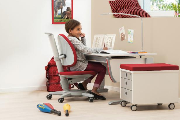 Ein Mädchen sitzt an einem Schreibtisch und macht Hausaufgaben.