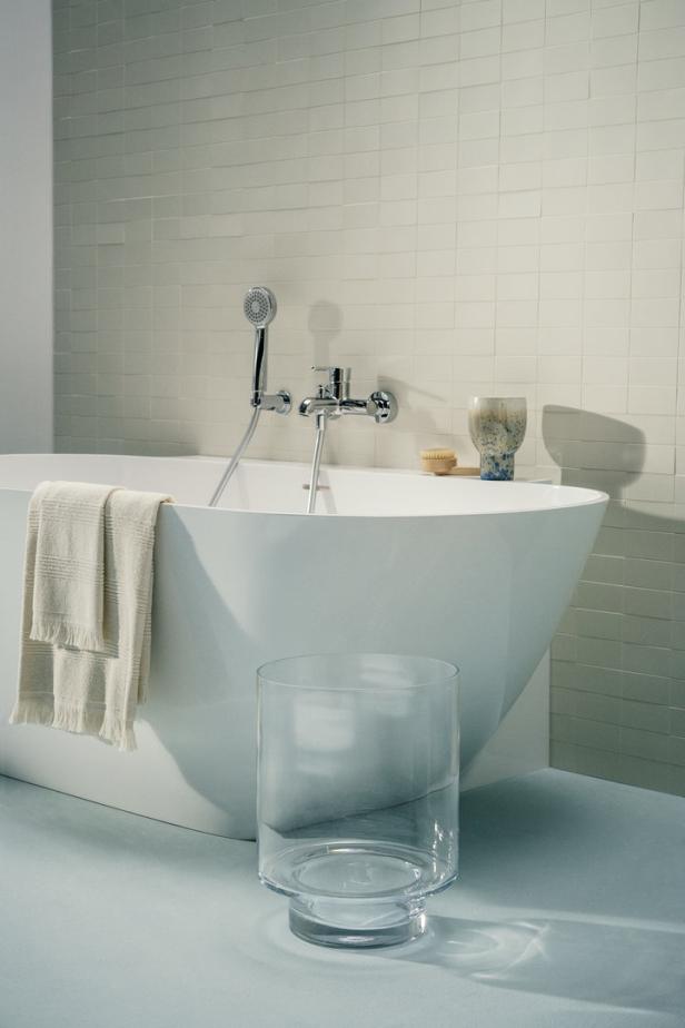 Ein modernes Badezimmer mit einer freistehenden Badewanne und hellen Fliesen.