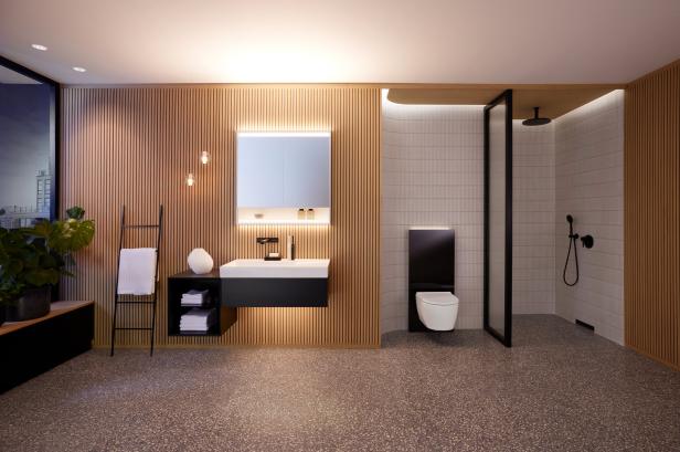 Ein modernes Badezimmer mit Holzwand, Waschtisch, Toilette und Dusche.