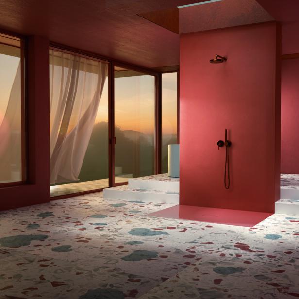Ein Badezimmer mit Terrazzoboden, einer Dusche und einem Blick auf den Sonnenuntergang.