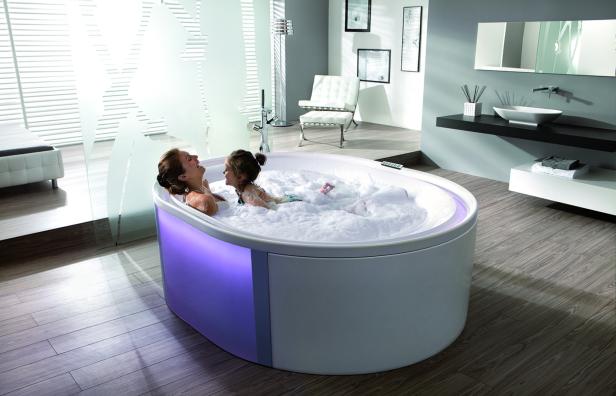 Eine Mutter und ihre Tochter haben Spaß in einer mit Schaum gefüllten Badewanne.