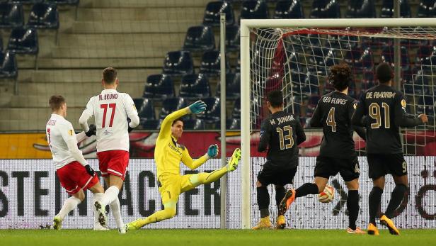 Ein Fußballtorwart in Gelb wehrt einen Schuss ab, während andere Spieler zusehen.