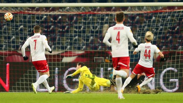Ein Fußballspiel mit mehreren Spielern in weißen und roten Trikots vor einem Tor.