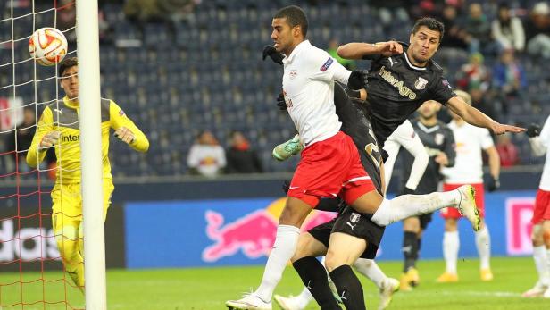 Ein Fußballspieler springt, um den Ball vor dem Tor zu köpfen.