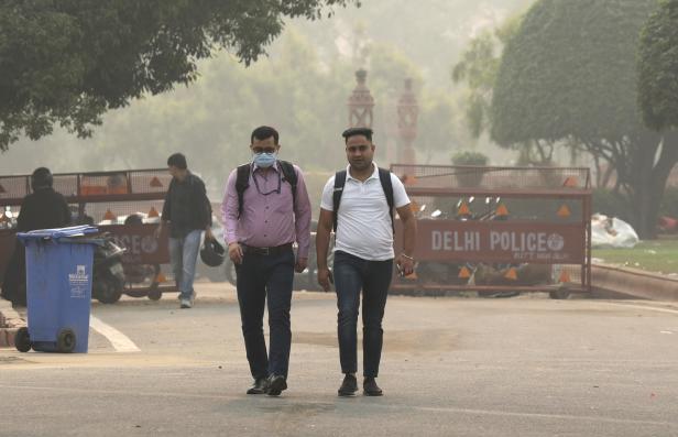 Ein indischer Mann trägt einen Mundschutz, als die Stadt in Neu-Delhi, Indien, am 02. November 2023 in starken Smog gehüllt ist. 